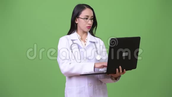 年轻漂亮的亚洲女医生用笔记本电脑视频的预览图