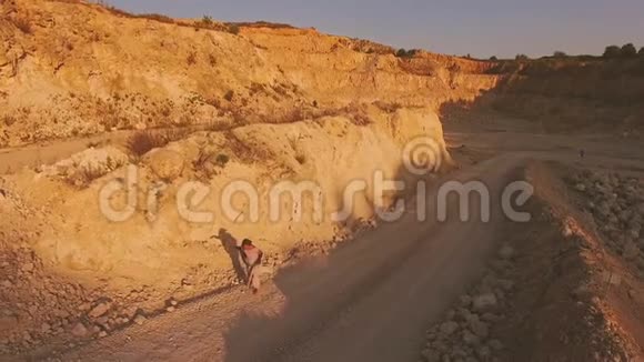 精疲力竭的妇女在一个废弃的地区沿着一条废弃的道路行走空中观景视频的预览图