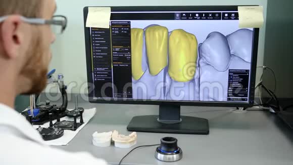 3D牙科数字建模眼镜技师在特殊程序中工作并在监视器上查看牙齿图像视频的预览图