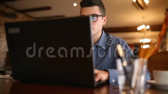 专注的年轻科技人自由职业者打断了他的笔记本电脑打字摘下眼镜微笑着直视着他视频的预览图