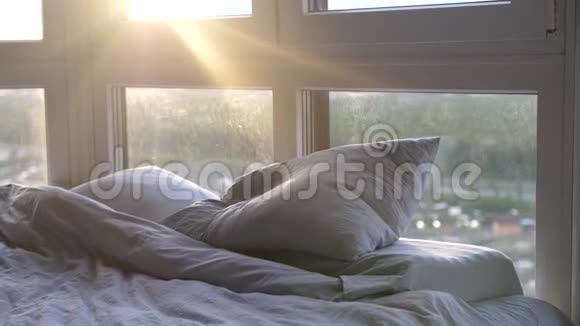 日出时在现代酒店客房提供空床阳光透过窗户照射有透镜耀斑效应视频的预览图