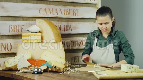 年轻的女卖家在柜台上装了一块奶酪视频的预览图