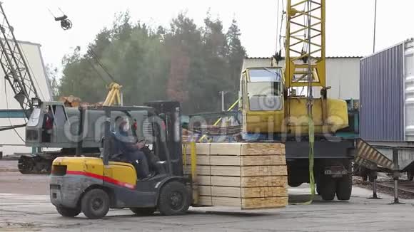 叉车在铁路车的背景下运输木板铁路货车装载木材视频的预览图