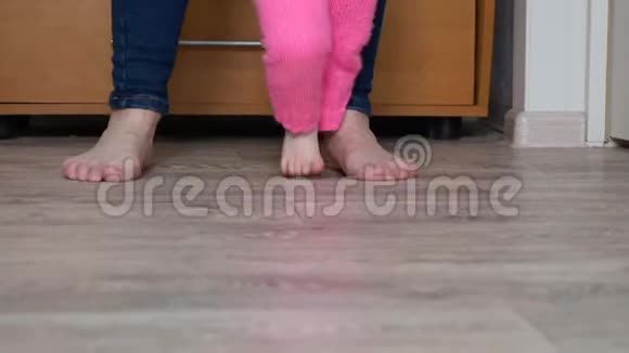 孩子和母亲的腿赤脚踩在地板上视频的预览图
