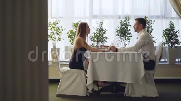年轻漂亮男人在餐馆约会时对漂亮年轻女士的求婚女人惊喜又快乐视频的预览图