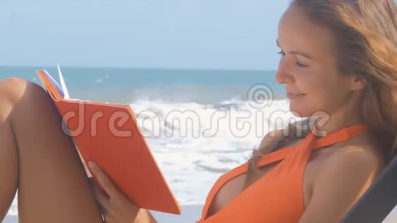 女人看海洋海岸的笔记本和写作视频的预览图