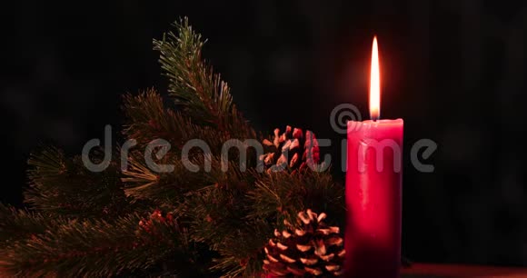 圣诞蜡烛用松果燃烧在桌子上视频的预览图