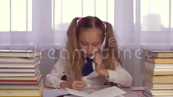 认真专注的女学生在桌子上做作业在学校笔记本上写字视频的预览图