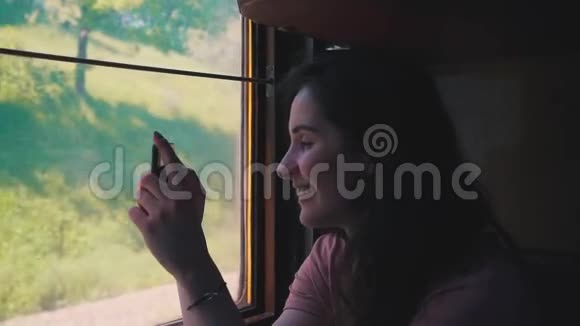 女孩正在从火车上拍照视频的预览图