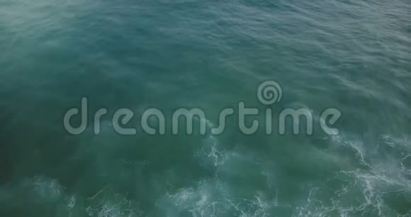 在蓝色和薄荷绿色的令人惊叹的天然海泡沫质地上无人机在海浪后面向后飞行视频的预览图
