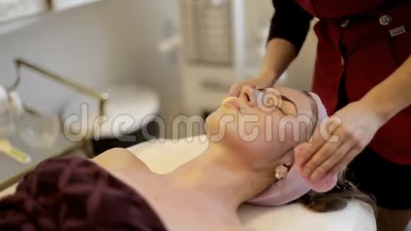 一个年轻的女孩在一个接待与美容师美容师正在准备洗脸视频的预览图