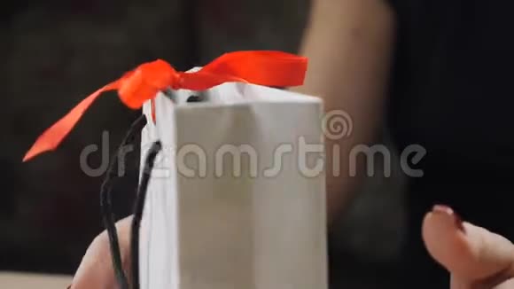 暗影浪漫的气氛开幕礼物快关门女人的手指打开礼物拿着盒子解开红丝带视频的预览图