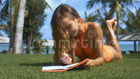 在棕榈树特写镜头的草地海滩上女孩光滑的头发视频的预览图