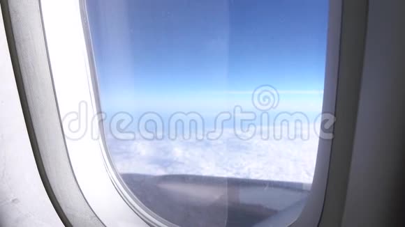 飞机飞行用手关上窗帘机翼在飞机的云层上方飞行旅行视频的预览图