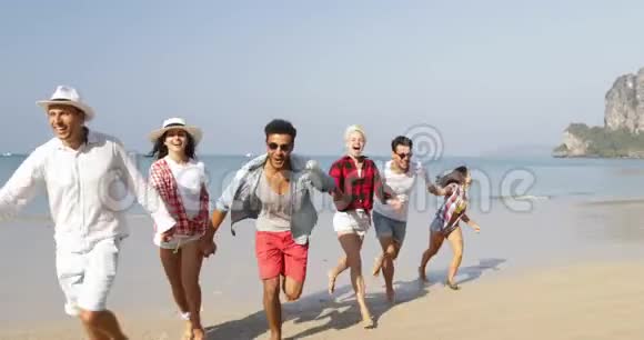 人们成群结队地在海滩上奔跑三对情侣手牵着快乐的快乐的男人和女人度假视频的预览图