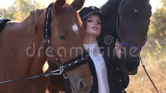 秋天公园里一个漂亮的女孩牵着两匹漂亮的马在缰绳后面视频的预览图
