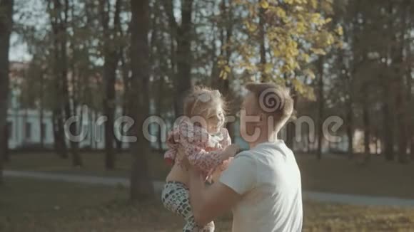 父亲和女儿在娱乐公园玩日落时慢动作视频的预览图