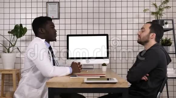 医生和他的男性病人谈话白色显示器视频的预览图