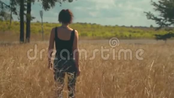 悲伤的女人走在阳光明媚的金色田野上视频的预览图