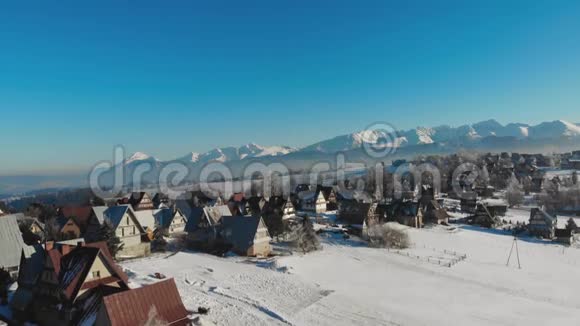在阳光明媚的山上雪山上的农舍和小屋视频的预览图