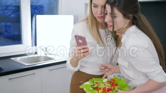 女朋友在厨房打电话看视频女朋友手里拿着沙拉视频的预览图