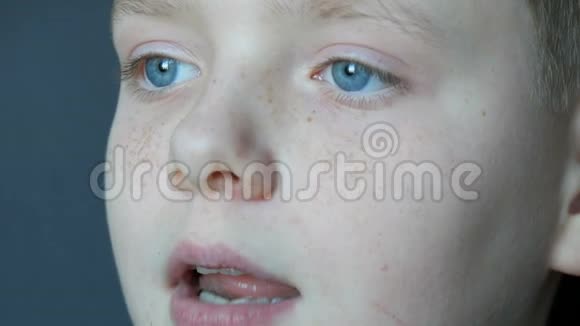 雀斑金发少年蓝眼睛吃巧克力糖闭目养神视频的预览图