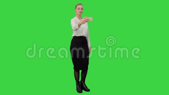 年轻漂亮的女商人用手机在绿色屏幕上自拍Chroma键视频的预览图