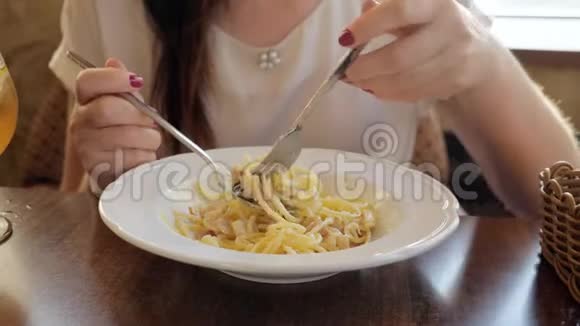 在咖啡馆里吃意大利面和培根的年轻女人视频的预览图