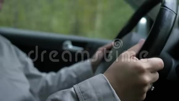 汽车车轮后面的年轻女孩方向盘上的手特写视频的预览图