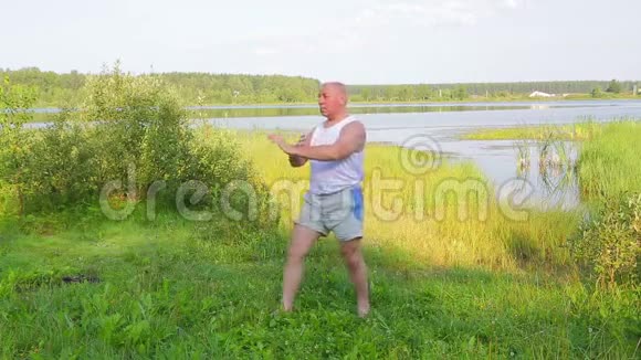 一位中年男子早上在湖边做瑜伽呼吸视频的预览图
