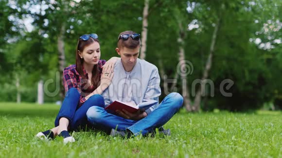 两个学生在草坪上读一本书调情笑语视频的预览图