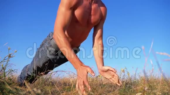 健身强壮的人做俯卧撑与拍打外面的自然慢动作视频的预览图