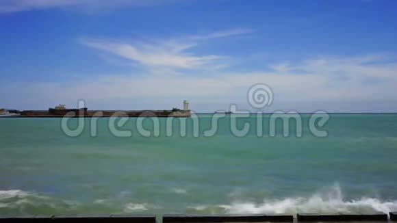 海上景观带波浪和观景码头带白色灯塔视频的预览图