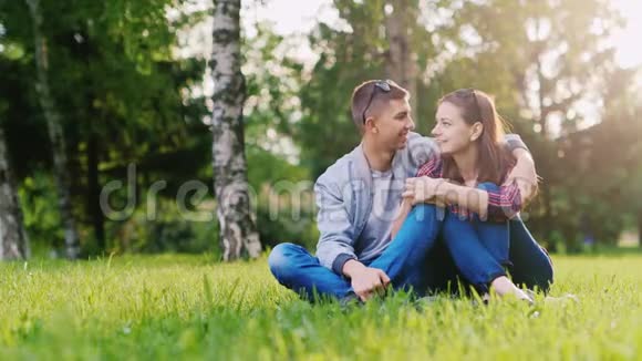 年轻迷人的夫妇在公园里放松拥抱微笑视频的预览图