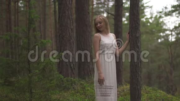 走着走着美丽的金发女郎穿着常绿木头的白衣森林仙女视频的预览图