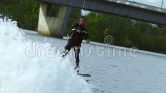 夏天的河上骑着尾箱的年轻人沃特斯基在飞溅中快速移动视频的预览图
