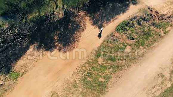 男子骑自行车在尘土飞扬的轨道上俯视视频的预览图