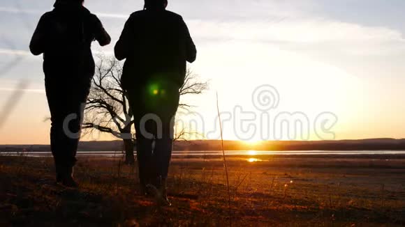 两个朋友夕阳西下往前走探险旅行的概念肩上背着一个背包视频的预览图