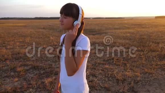 戴着耳机的女孩走在路上听音乐跳舞视频的预览图