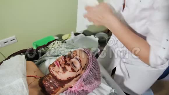 用海绵洗掉女孩脸上巧克力巧克力水疗疗法视频的预览图