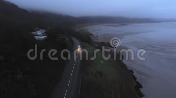 驾驶汽车在海边的一条小路上从上面可以看到黑暗的景色视频的预览图
