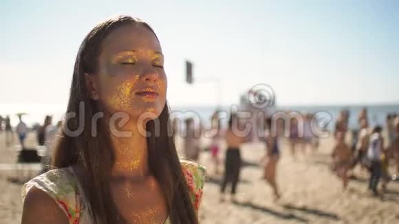 阳光明媚的海滩和女孩脸上的金色闪光肖像视频的预览图