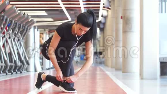 女孩子在健身馆做鞋带然后跑步锻炼视频的预览图