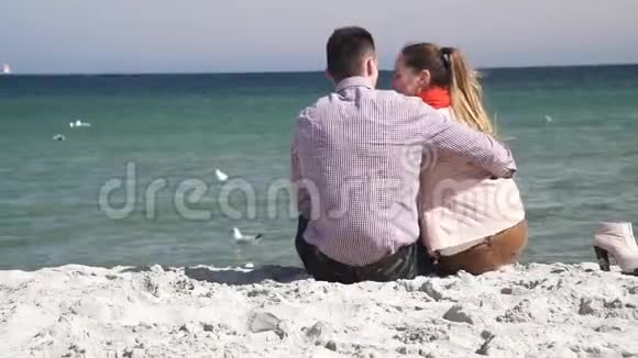 坐在沙滩上欣赏海景的情侣视频的预览图