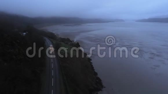 驾驶汽车在海边的一条小路上从上面可以看到黑暗的景色视频的预览图