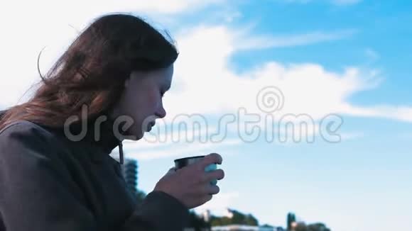 女人喝茶年轻的黑发女人在旅途中视频的预览图