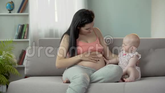未来的妈妈等着生孩子可爱的孩子抚摸怀孕的肚子视频的预览图