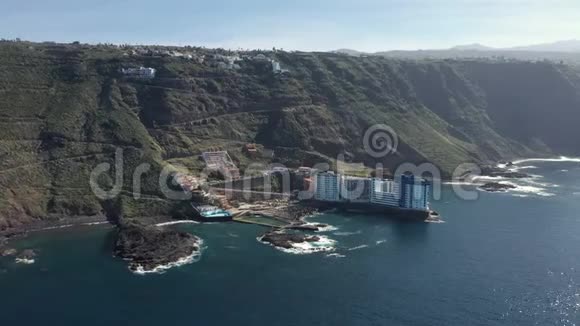 在岛上陡坡坡脚的鸟瞰酒店综合体视频的预览图