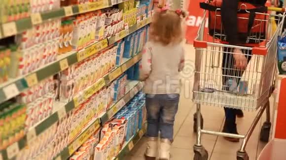 小女孩在超市里选择和购物婴儿食品视频的预览图