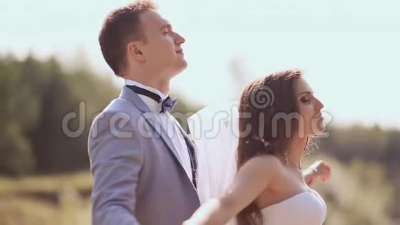 一对新婚夫妇在他们的婚礼日在湖边的绿色自然中他们在世界上视频的预览图